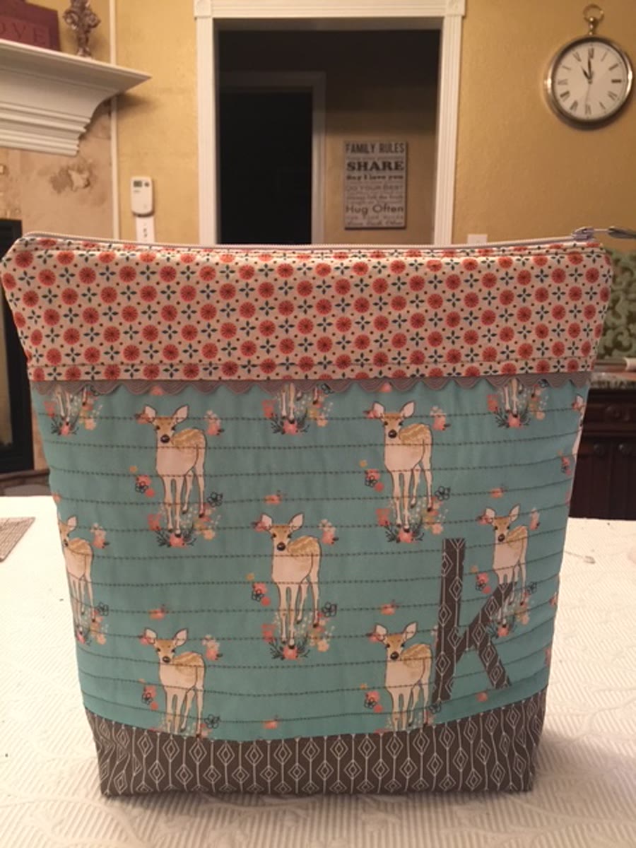 A finished quilted zipper pouch in deer print fabric, one of the two first projects